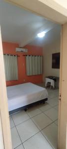 ein Schlafzimmer mit einem Bett und einem Tisch in einem Zimmer in der Unterkunft POUSADA ACONCHEGO HOTEL in Imperatriz