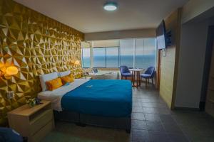Golden Mar Hotel في ليما: غرفة فندقية بسرير وطاولة وكراسي