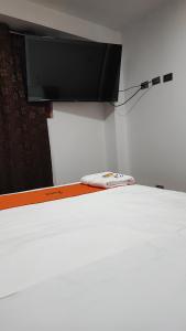 Schlafzimmer mit einem Bett und einem Flachbild-TV an der Wand in der Unterkunft GOLDEN PARIS Hotel in Ayacucho
