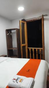 a bedroom with a bed with an orange blanket and a window at GOLDEN PARIS Hotel in Ayacucho