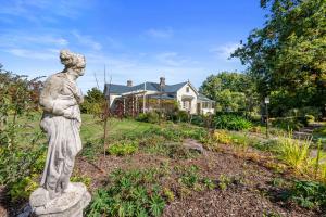 a statue in a garden in front of a house at Tanglewood House - The Master Suite, Sheffield Tasmania in Sheffield