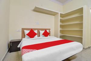 a bedroom with a large bed with red pillows at 80983G RBS Square Langer Houz in Haidar Sāhibgūda