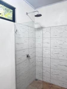 La salle de bains est pourvue d'une douche avec une porte en verre. dans l'établissement Bella's Country Room, à Tanque