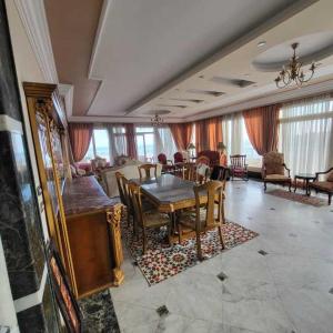 a dining room with a table and a living room at شقه فى ميامى بالاسكندريه مطله على البحر in Alexandria