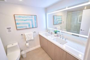 a bathroom with a sink and a toilet and a mirror at Luxury at its Finest in Larchmont W. Roof Deck in Los Angeles