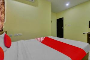 a bedroom with a red and white bed and a black door at Flagship Hotel Abhi's R Square Near Hayathnagar in Pedda Ambarpet