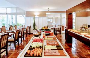 un restaurante con una mesa larga con comida. en Hotel M-RCURE Vila Olímpia - The Best Smart Urban Duplex - Executive Edition - By LuXXoR en São Paulo