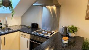 a kitchen with a stove top oven next to a sink at Studio one bedroom En-Suite with Kitchenette in Easthampstead