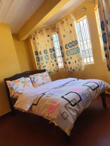 sypialnia z łóżkiem i 2 oknami w obiekcie MAGGY LODGE w mieście Kagio