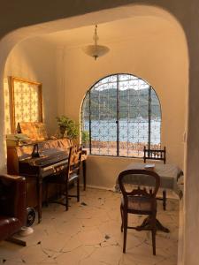 a living room with a piano and a window at Rosarii Pacis Villa - Venuestay in Thôn Bình Hưng