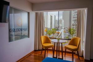 um quarto com uma mesa e duas cadeiras e uma janela em Golden Mar Hotel em Lima