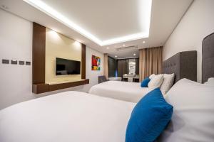 Una habitación de hotel con dos camas y un televisor. en Sweet May Seogwipo Hotel, en Seogwipo 20 fotos más