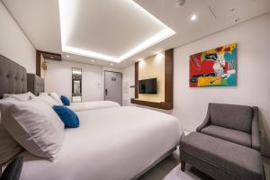 מיטה או מיטות בחדר ב-Sweet May Seogwipo Hotel