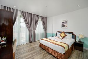 a hotel room with a bed and windows at Harry Phu Quoc Hotel in Phú Quốc