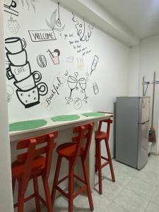 una cocina con encimera con taburetes y dibujos en la pared en CONNOLLY'S APARTMENTS en San Andrés