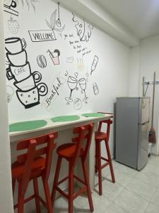 una cocina con encimera con taburetes y dibujos en la pared en CONNOLLY'S APARTMENTS, en San Andrés