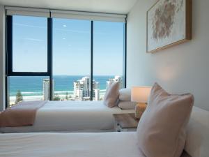 two beds in a room with a view of the ocean at The Gallery Residences Broadbeach - Official Listing in Gold Coast +80 photos