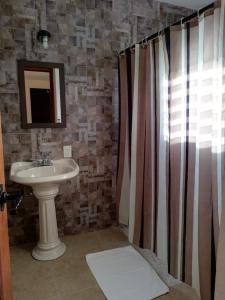 uma casa de banho com um lavatório e uma cortina de chuveiro em HDA VALENTINA em Playa del Carmen