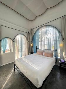 a bedroom with a large bed with two windows at Rosarii Pacis Villa - Venuestay in Thôn Bình Hưng