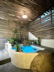 una bañera de hidromasaje en una habitación con plantas. en Rosarii Pacis Villa - Venuestay en Thôn Bình Hưng