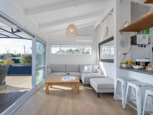 a living room with a couch and a table at Sol Vista Paku - Pauanui Holiday Home in Pauanui