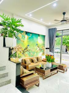 una sala de estar con una gran pintura en la pared en Villa Quy Nhơn Gần Biển Gần Trung Tâm - Biệt Thự Quy Nhơn Gần Biển en Quy Nhon