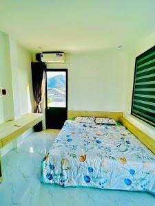 a bedroom with a bed with a blue comforter at Villa Quy Nhơn Gần Biển Gần Trung Tâm - Biệt Thự Quy Nhơn Gần Biển in Quy Nhon