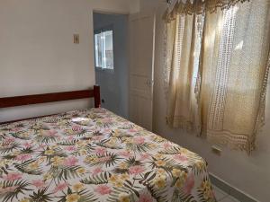 ein Schlafzimmer mit einem Bett mit geblümter Tagesdecke in der Unterkunft Casa Itamaracá in Itamaracá + 59 Fotos