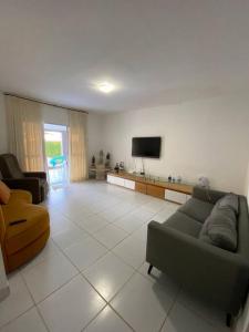 ein Wohnzimmer mit Sofa und Fernseher in der Unterkunft Casa Itamaracá in Itamaracá