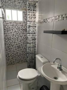 ein weißes Badezimmer mit Toilette und Waschbecken in der Unterkunft Casa Itamaracá in Itamaracá
