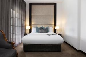 ein Schlafzimmer mit einem großen weißen Bett mit blauen Kissen in der Unterkunft Mineral Springs Hotel Hepburn in Hepburn Springs