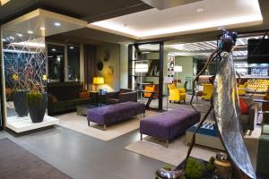 a living room with purple and yellow furniture at Park Hotel Almaty in Almaty