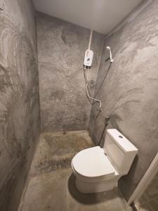 a bathroom with a toilet and a phone on the wall at Social Quarters in Railay Beach