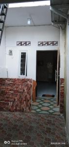 um quarto vazio com uma parede de tijolos e um sofá em Home stay & Kost syariah SONY CA E.15 em Batu Hampar