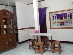 uma mesa e alguns bancos num quarto em Home stay & Kost syariah SONY CA E.15 em Batu Hampar