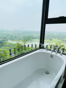 um lavatório de casa de banho em frente a uma janela com vista em Elite House, Ecopark Swanlake _ Onsen, view Hồ Thiên Nga em HÆ°ng YÃªn