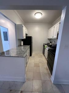 una cucina con armadietti bianchi ed elettrodomestici neri di Cozy 1BR Condo a West Hartford