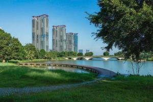 uma ponte sobre um rio num parque com edifícios altos em Elite House, Ecopark Swanlake _ Onsen, view Hồ Thiên Nga em HÆ°ng YÃªn
