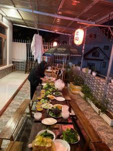 Alex Home Đà Lạt في دالات: طاولة طويلة عليها أطباق من الطعام