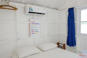1 dormitorio con 1 cama con cortina azul en Le Pirate Beach Club Nusa Ceningan - Adults Only, en Nusa Lembongan