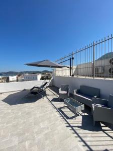 patio con divano, tavolo e ombrellone di La fortezza a Ischia