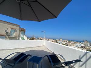 d'une table et de chaises sur un balcon avec un parasol dans l'établissement La fortezza, à Ischia