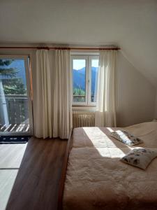 een slaapkamer met een bed en een groot raam bij Ferienhaus Häusler 