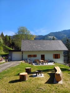 a building with a picnic table and logs in front of it at Ferienhaus Häusler in Sankt Erhard