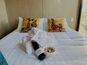 a towel elephant on a bed with a bowl of candy at The Outlook in Diamond Harbour