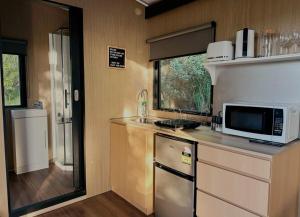 uma cozinha com um micro-ondas e um balcão com um lavatório em The Outlook em Diamond Harbour