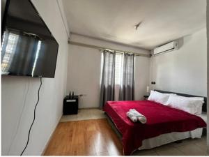 een slaapkamer met een rood bed en een flatscreen-tv bij Beresford boutique in Kingston