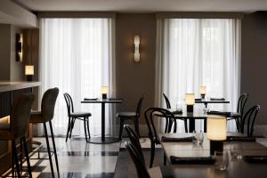 a dining room with tables and chairs and windows at The Lyall in Melbourne