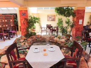 a table and chairs in a restaurant with a stone wall at Spa Hotel Alex in Loutra Edipsou