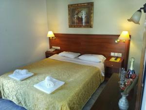 - une chambre d'hôtel avec 2 lits et des serviettes dans l'établissement Spa Hotel Alex, à Loutra Edipsou